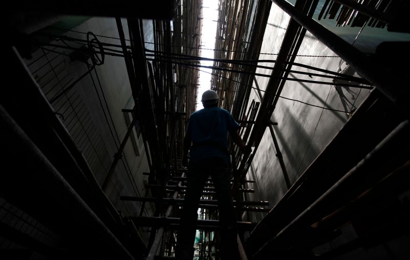 A worker stands on scaffolds at a construction site in