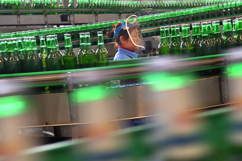Woman works at the production line at a beer factory