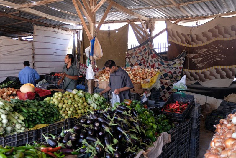 People shop at a vegetable market in Sirte