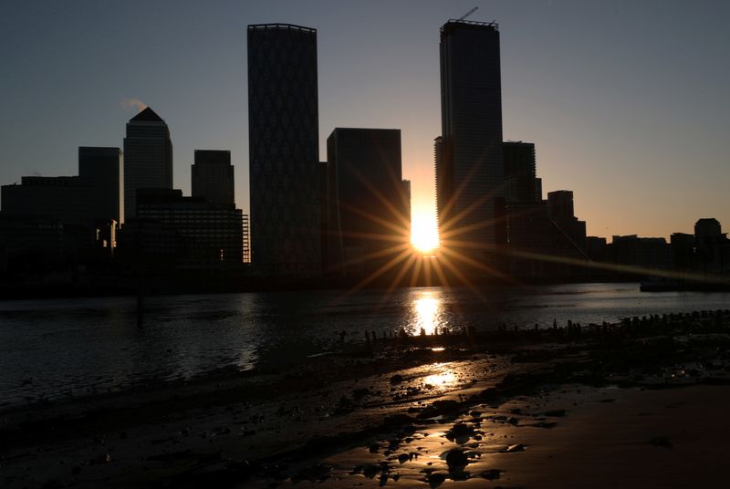 The sun rises behind the Canary Wharf financial district in