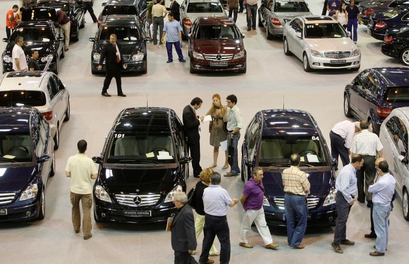FILE PHOTO: People take a look at second-hand cars at