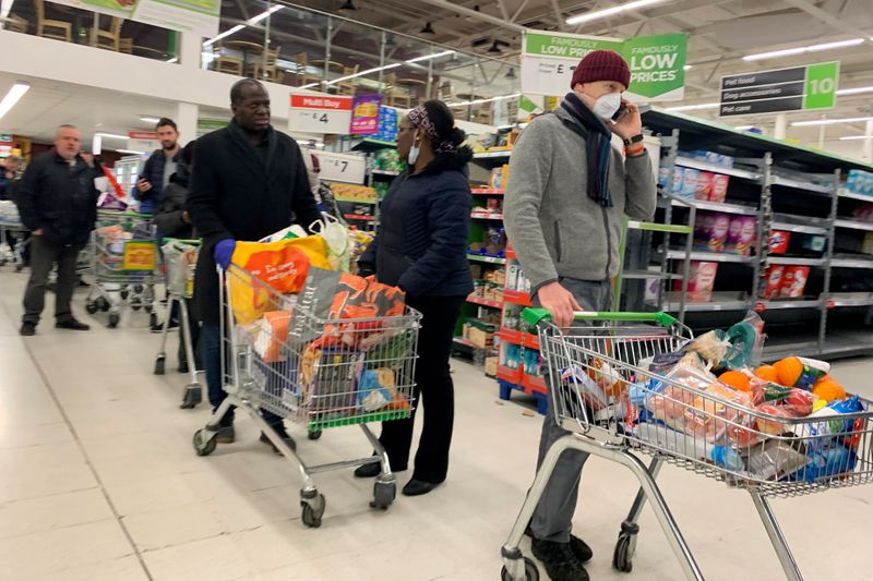 FILE PHOTO: Shoppers queue at a supermarket in London