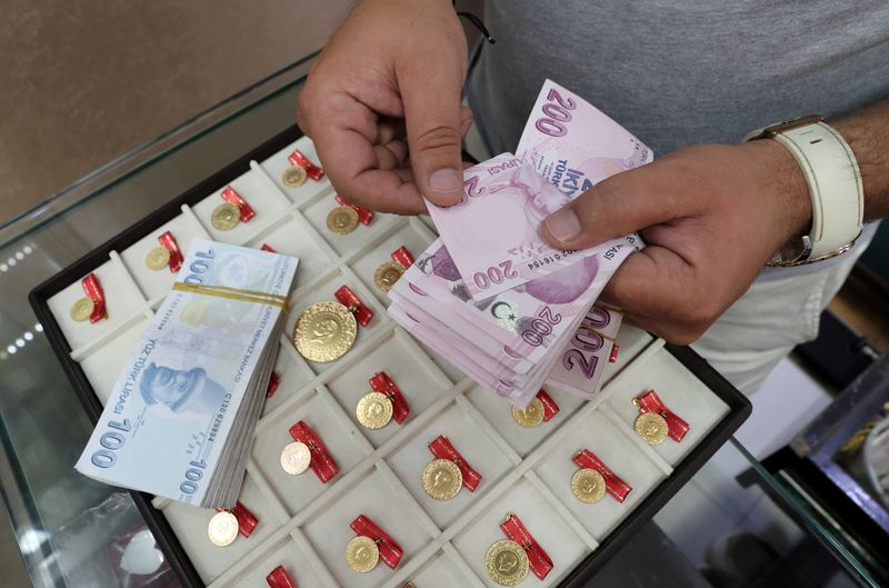 FILE PHOTO: FILE PHOTO: A gold dealer counts Turkish lira