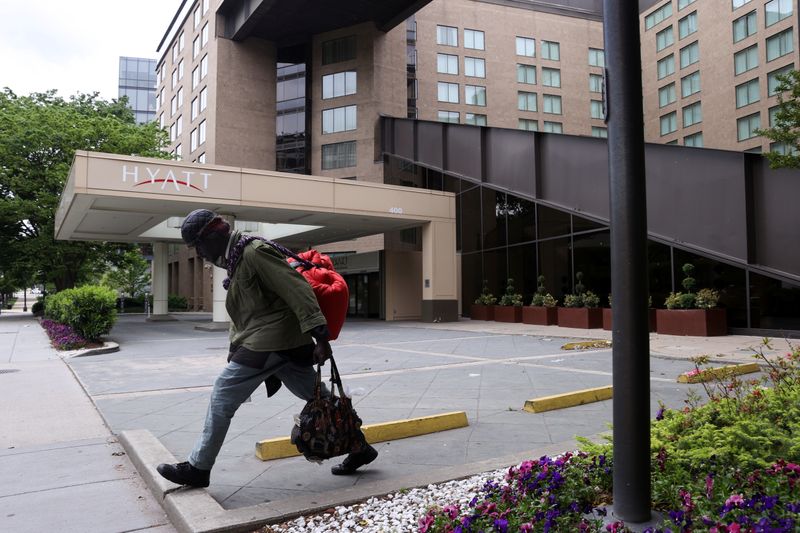 A member of the homeless community walks past a Hyatt