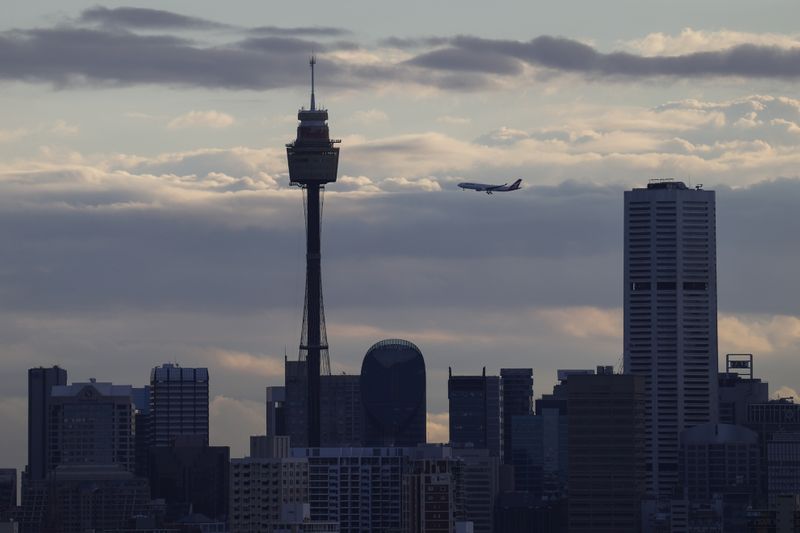 A Qantas plane flies over the city centre skyline in