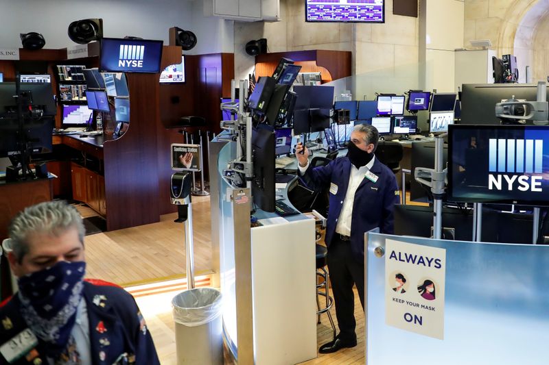 Traders wearing masks watch as the Opening Bell rings, on