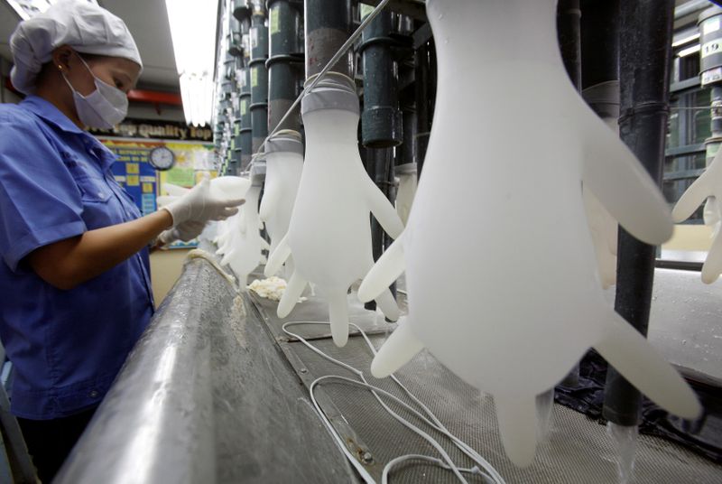 FILE PHOTO: A worker inspects gloves at a Top Glove