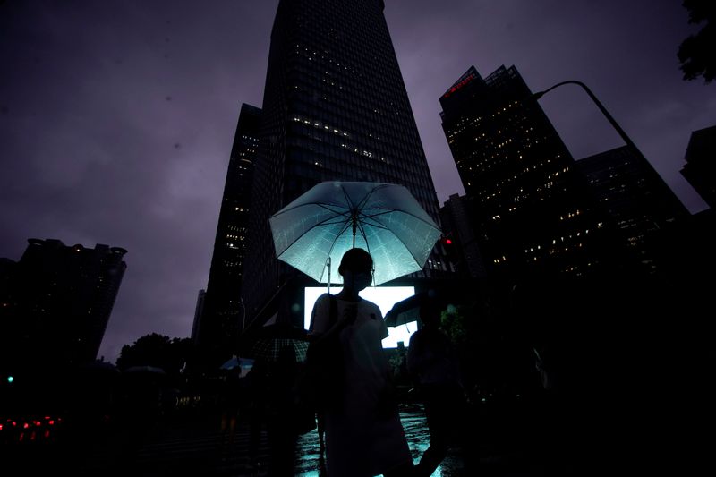 A woman walks with an umbrella in Lujiazui financial district