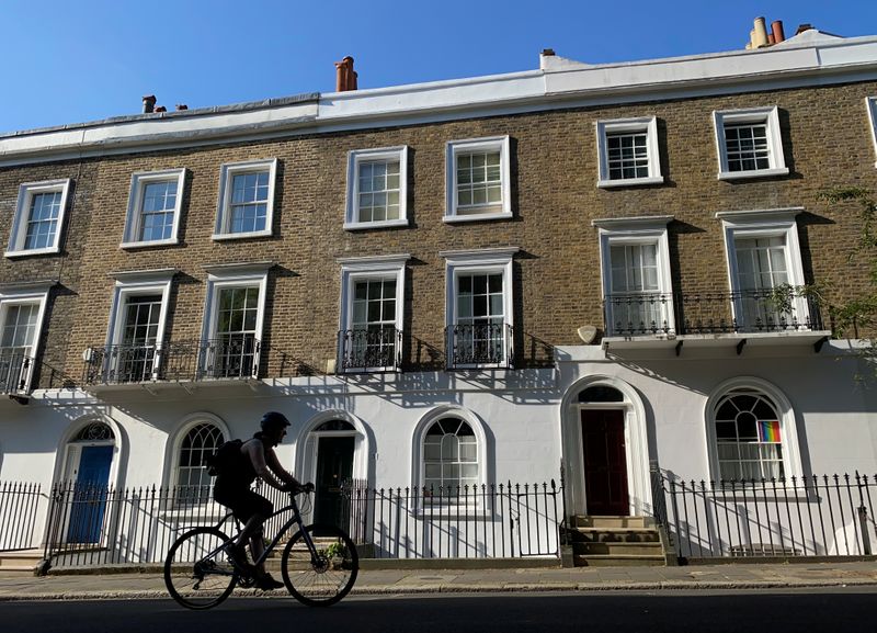 A cyclist rides past houses on a street in Islington,