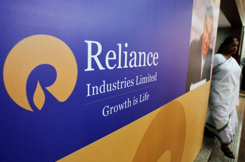 FILE PHOTO: A woman walks past a poster of Reliance