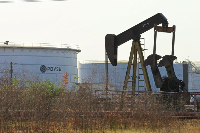FILE PHOTO: An oil pumpjack and a tank with the