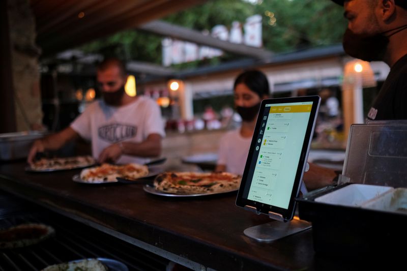 FILE PHOTO: Employees pick up the pizzas near an IPad