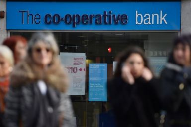 People walk past a branch of The Co-operative Bank in