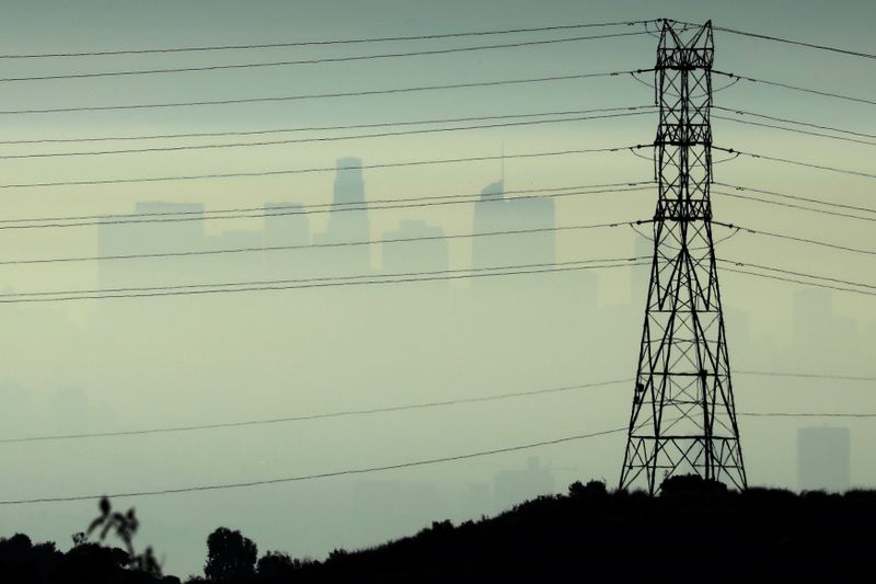 Downtown Los Angeles is seen behind an electricity pylon through