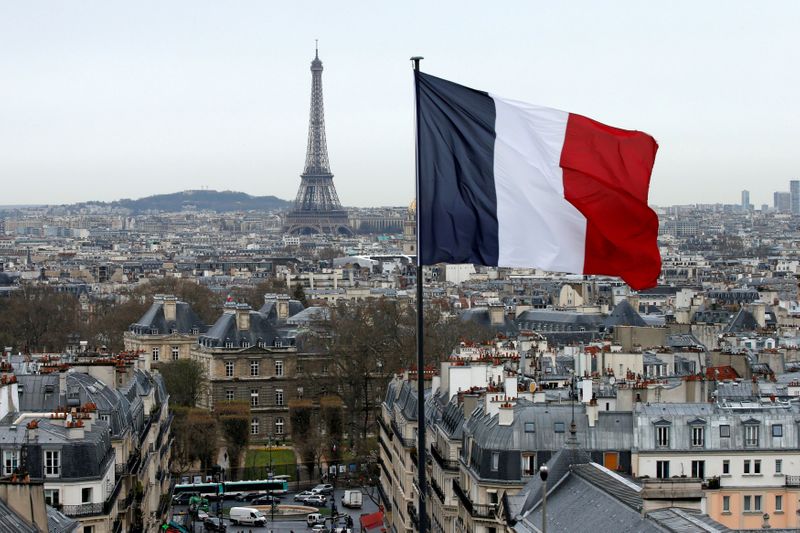 FILE PHOTO: A French flag waves above the skyline as