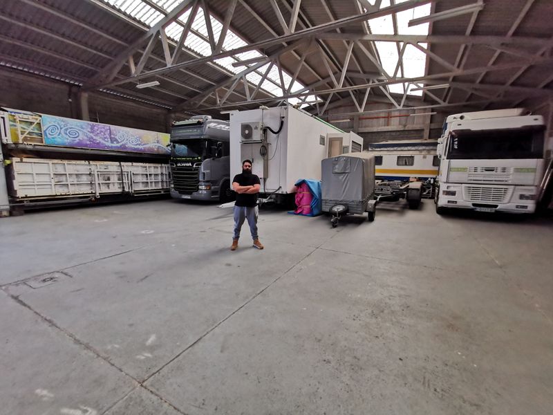 Juan Balsa poses in front of their trucks in a