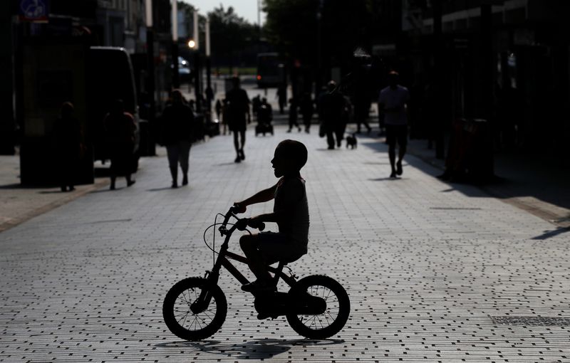 FILE PHOTO: A child cycles his bike across a quiet
