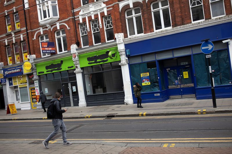 Pedestrians walk past closed retail stores in Croydon, south London