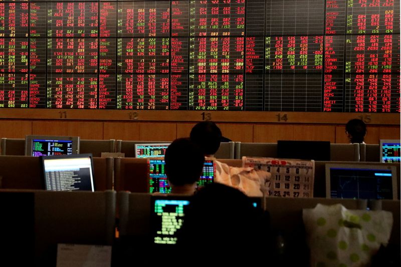 FILE PHOTO: Traders are seen in front of a screen