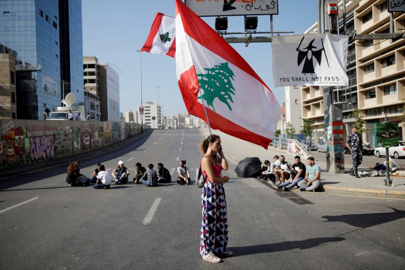 FILE PHOTO: A woman holds a Lebanese flag as she