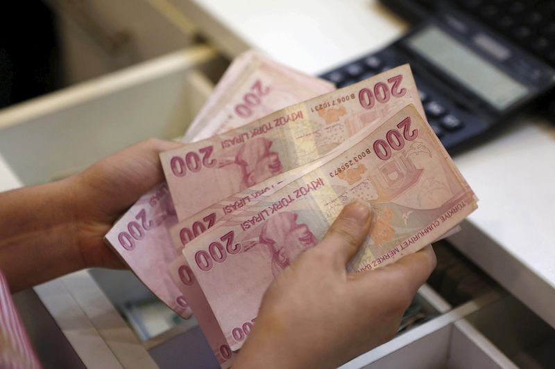 A money changer counts Turkish lira bills at an currency