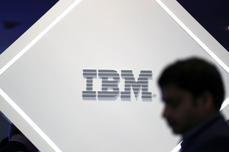 A man stands near an IBM logo at the Mobile