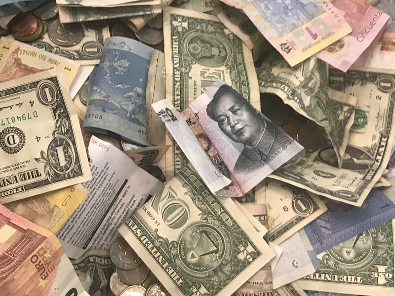 FILE PHOTO: U.S. dollars and other world currencies lie in