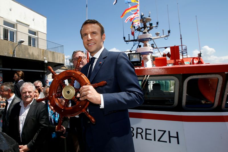 FILE PHOTO: French President Emmanuel Macron receives a gift on