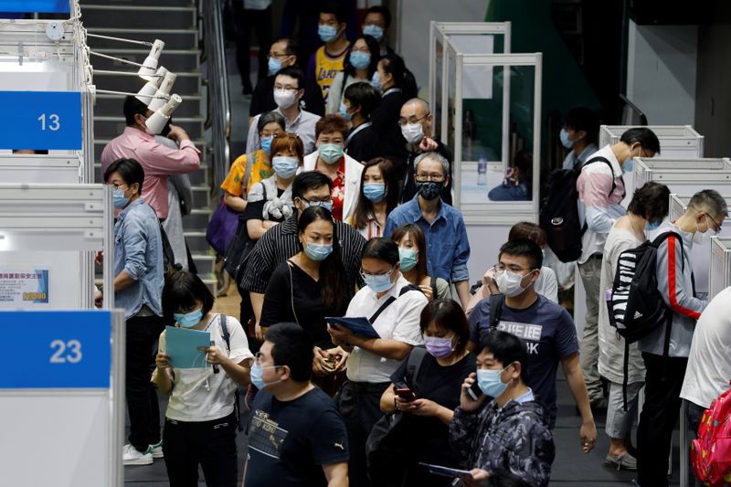 Job seekers wearing face masks fill in forms at the