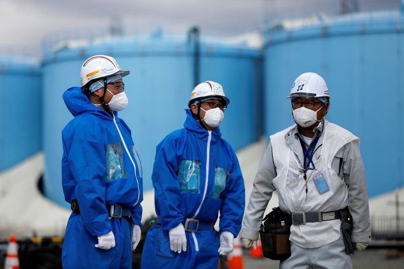 FILE PHOTO: Workers are seen in front of storage tanks