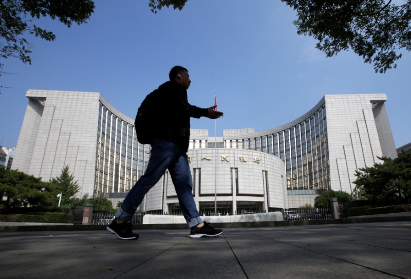 A man walks past the headquarters of the PBOC, the