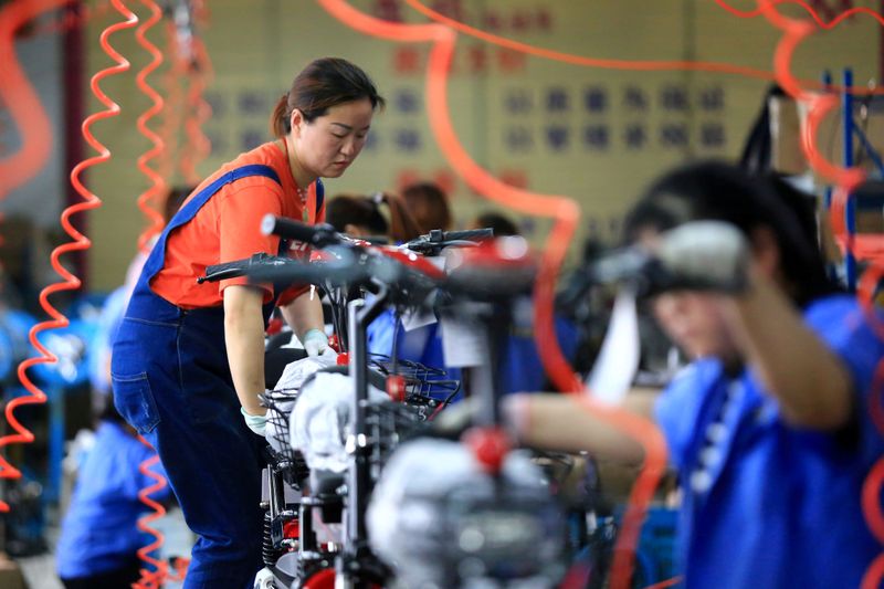 FILE PHOTO: Woman work on manufacturing electric bicycles at a