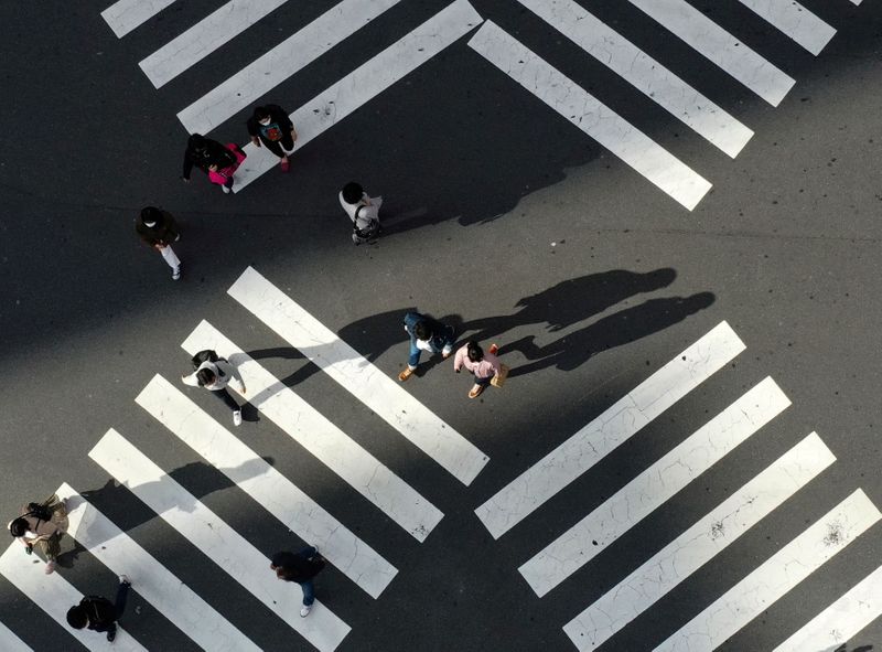 FILE PHOTO: People cross a street in front of Shinjuku