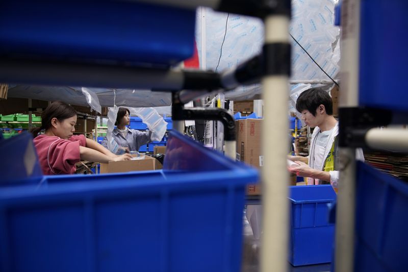 Employees work at a warehouse of Cainiao, Alibaba’s logistics unit