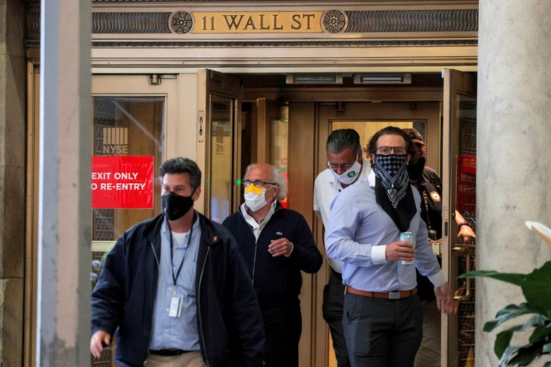 Traders exit the 11 Wall St. door of the NYSE