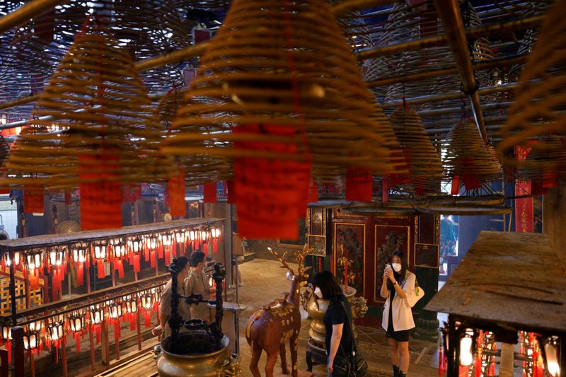 FILE PHOTO: Visitors wearing face masks visit Man Mo Temple