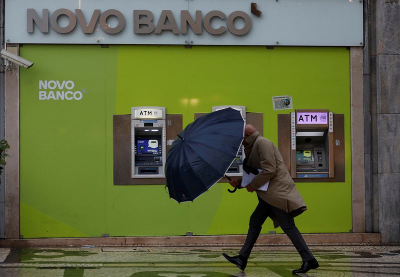 FILE PHOTO: A man walks near ATM machines of a