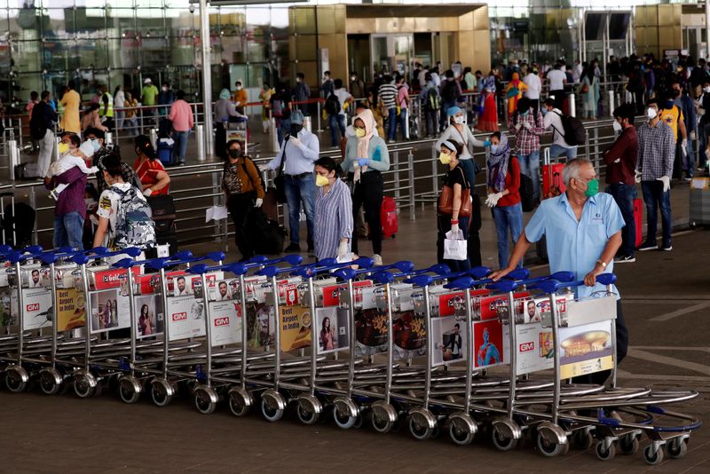 FILE PHOTO: An airport staff member pushes trolleys at Mumbai’s