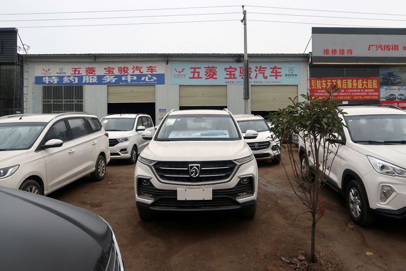 Baojun cars wait for sale in front of a dealership