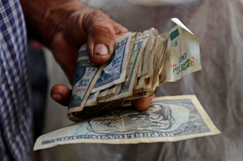 A farmer holds a wad of Cuban money at a