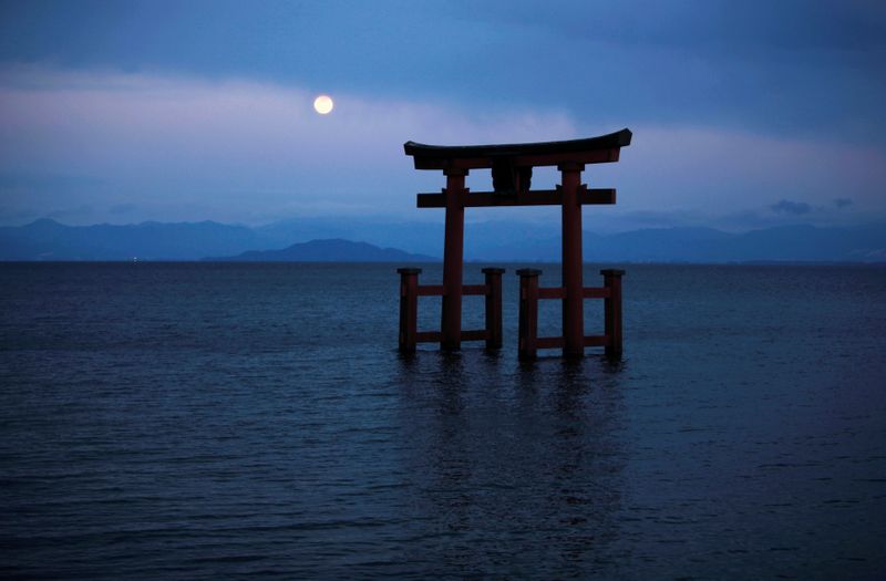 FILE PHOTO: A Shinto shrine gate, with the moon behind