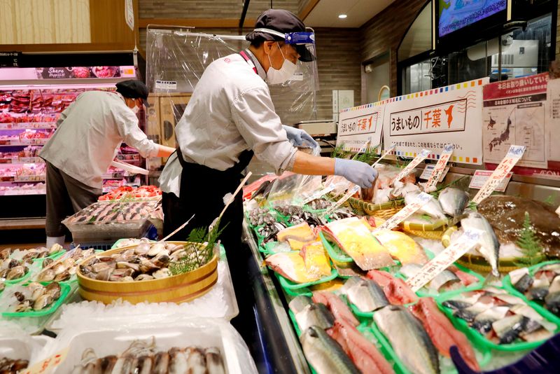 FILE PHOTO: A staff wearing a face shield sells fish
