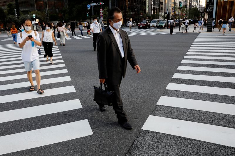 FILE PHOTO: People wearing protective masks make their way at
