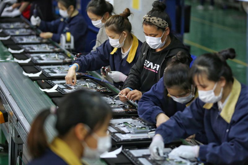 FILE PHOTO: Employees wearing masks work on a production line