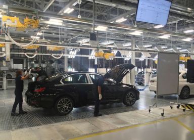 FILE PHOTO: Employees work on a BMW 3 Series car