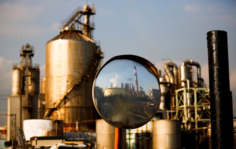 A factory is reflected in a traffic mirror at the