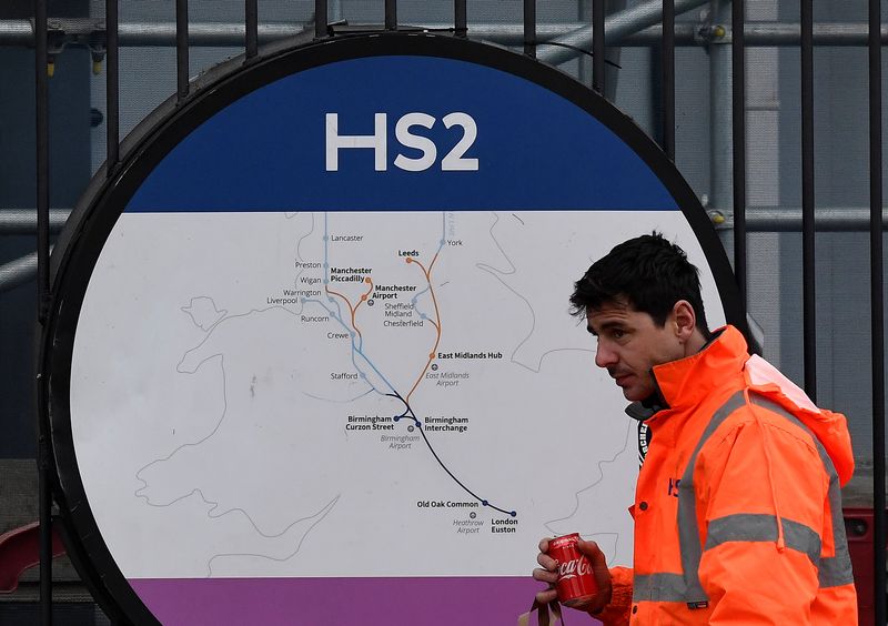 FILE PHOTO: An HS2 worker walks past signage on perimeter