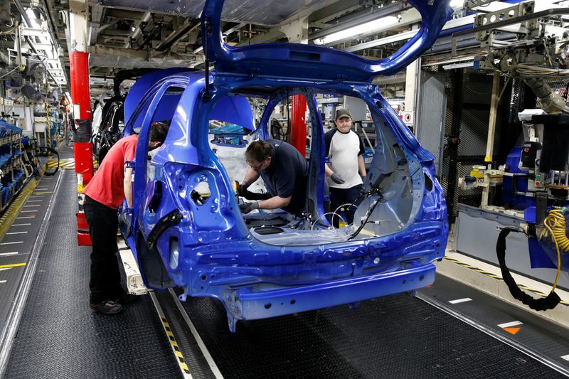 Employees work on the assembly line to build Yaris cars