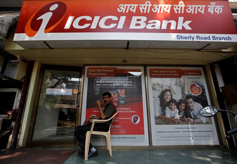 A security guard sits outside an ICICI bank branch in