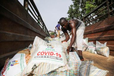 Men load sacks of rice in Abuja